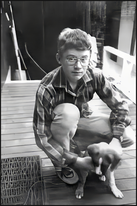 Photo of Dann Arthur, schoolboy of Tapanui, crouching down patting his dog.