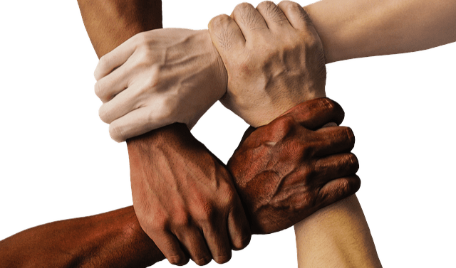 Photo of four hands, with each hand holding another persons wrist to form a square.